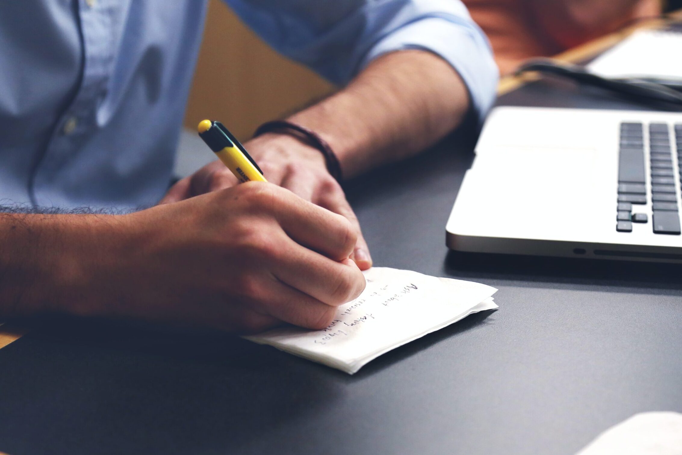 Free Person Writing on Paper Using Yellow and Black Pen Stock Photo